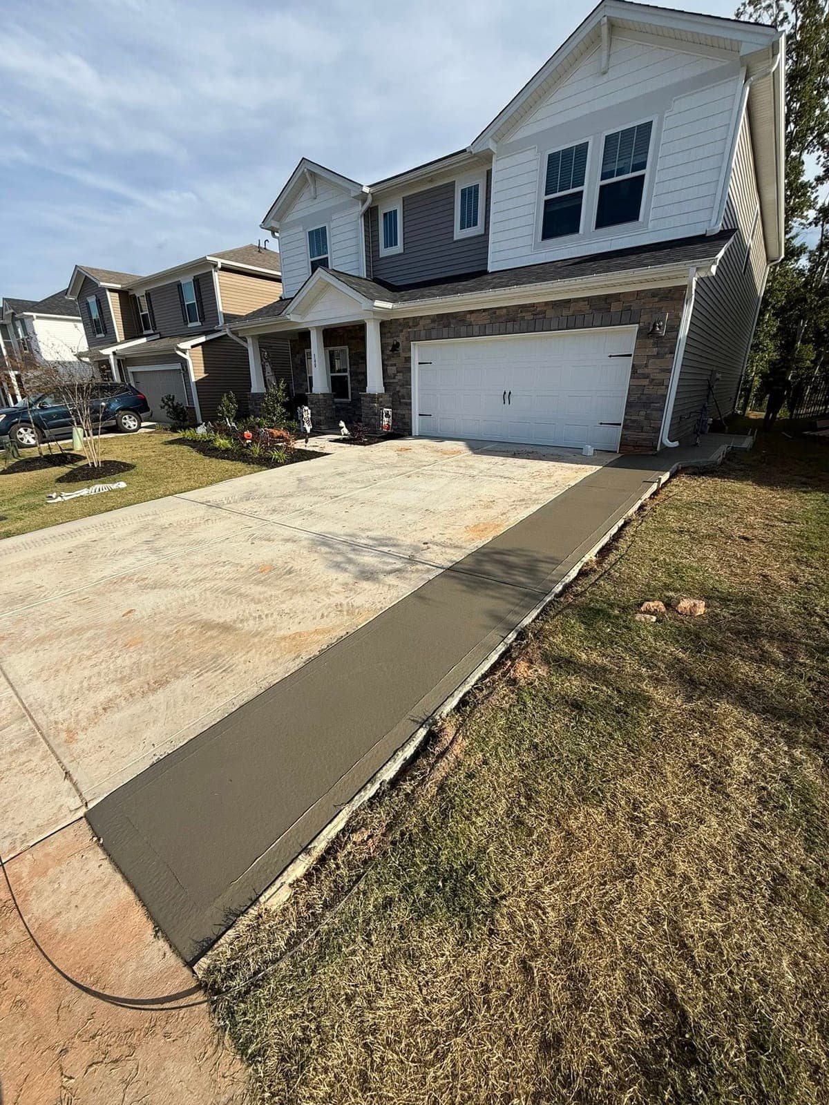Newly poured Concrete Driveway Extensions in Apex, NC (Wake County) by Local Concrete Contractor — 4000 PSI mix, double-mat #4 rebar, broom-finish surface, 28-day full cure.